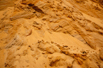 Textural sand, with  relief surface, multi-colored layers and different in size of granules, in outdoor sand career, after mining ore and sand for construction.
