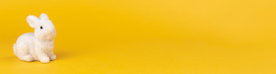 Easter bunny postcard or greeting card for spring holiday. Wide banner design. Bright yellow background with copy space, free space for text photo