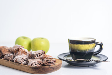 Sweet pastille of apples in rolls with cup of tea. Healthy sweets - fruit chips. Natural sweets from berries and fruits. Diet vitamin and vegan food. Copyspase.