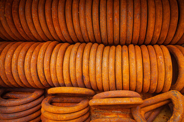 Stacked to each other rusty steel rings for securing loads, top view.