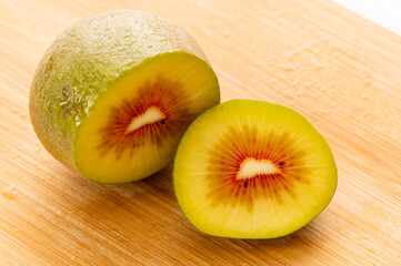 Red Kiwi fruit berry cut slice on wooden board healthy breakfast diet
