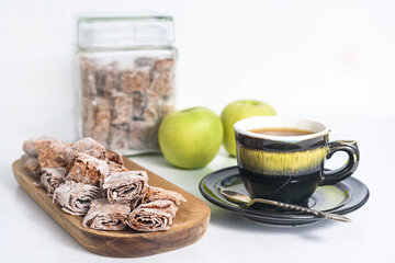 Sweet pastille of apples in rolls with herbal tea. Healthy sweets - fruit chips. Natural sweets from berries and fruits. Diet vitamin and vegan food.