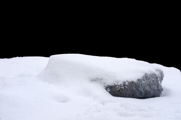 natural stone in snow isolated on black background