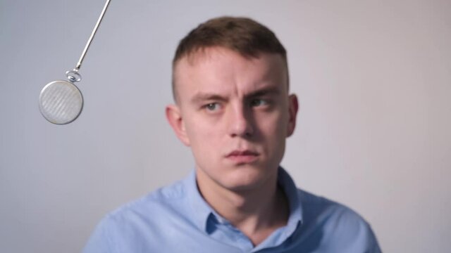 A man enters hypnosis while watching a swinging pendulum