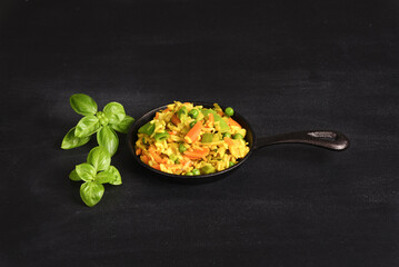 Rice with vegetables and yellow seasoning in a pan.