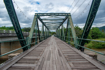 Green steel bridge with wooden plank walkway 