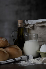 Bread rolls,  Flour, milk and eggs on wood table.Breakfast or cooking concept.