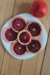 Cut the red orange into circles on a plate.	
