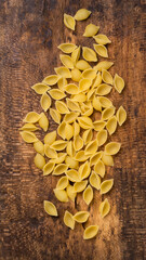 uncooked pasta scattered on a wooden surface, diet and food concept, taken from above