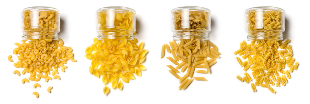 variety of uncooked pasta scattered out of glass bottles, isolated on white background, diet and food concept, collection