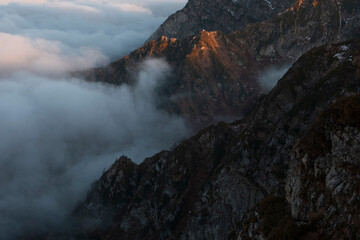 Fantastic dreamy sunrise on top of rocky mountain .Mountain view.Foggy Sunrise clouds. .Misty peaks.Foggy landscape background.