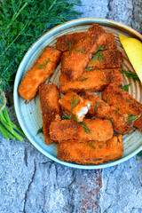 Close up of   Crispy breaded  deep fried fish fingers with breadcrumbs served  with remoulade sauce and  lemon Cod Fish Nuggets on rustic wood table background