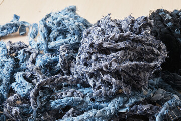 balls of denim yarn on the table, reasonable consumption, second life to old things concept, pigtails from cut jeans