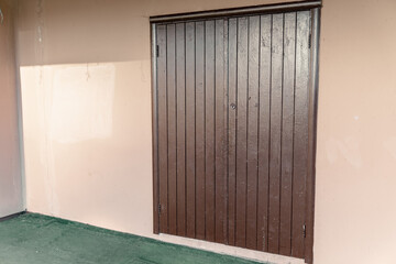 Beige wall with a wooden door without handles