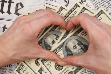 hand with money, hands in the form of heart on the money backgraund