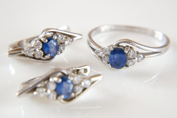 Jewelry. beautiful silver earrings pair and ring set with blue sapphire stones on white background