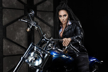 Plakat girl on a motorcycle. black long hair. dreadlocks
