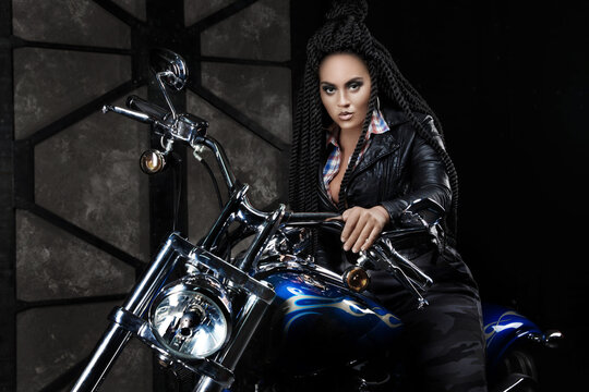 girl on a motorcycle. black long hair. dreadlocks