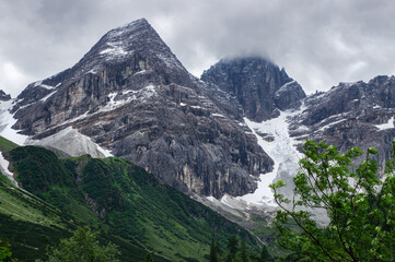 Mountain peak rising majestically from the green in the alps.