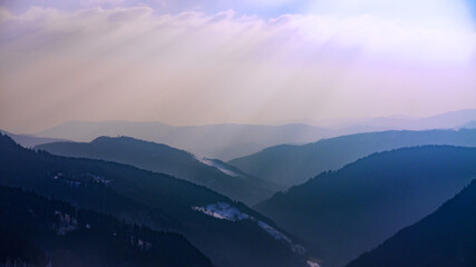 View over hills of the Black Forest caught in the haze against the sun.