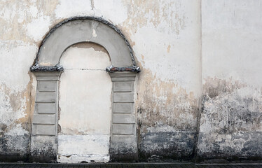 Fototapeta premium An old church wall of gray brick with a walled door on it.
