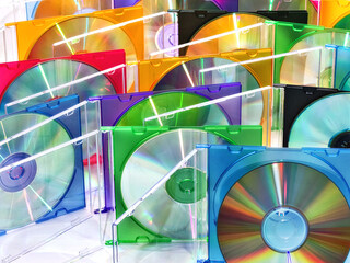 colorful compact discs in boxes stacked in a pile as background