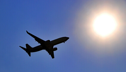 Fototapeta na wymiar Jet airliner silhouetted against the sun
