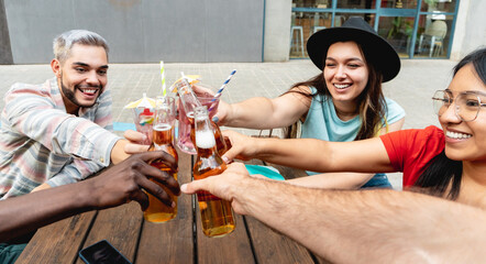 Young friends having fun during happy hour drinking beer at brewery bar restaurant - Festive,...