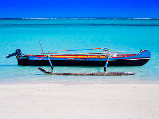 Multi-colored outrigger fishermen pirogue moored on turquoise sea of Nosy Ve island, Indian Ocean,...