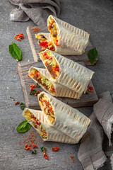 A delicious doner donair kebab wrap with meat, lettuce, tomato,  onion and sauce.