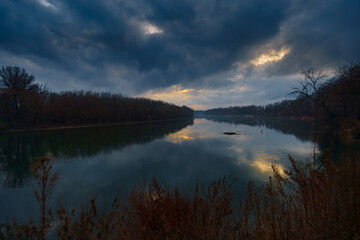 Fototapeta premium a beautiful autumn landscape in the evening - forest with river and cloudy sky