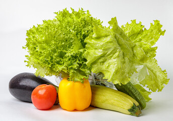 Set of fresh raw vegetables on a white background. Salad, tomatoes, cucumbers, eggplants, zucchini