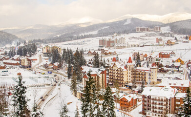 Fototapeta na wymiar Amazing winter landscape of Bukovel ski resort. Wooden houses, hotels near snowy mountains