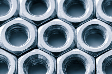 Metal nuts in a row background. Chromed screw nuts. Steel nuts pattern. Tools for work.