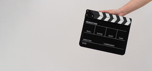 Hand is holding Black clapperboard or movie slate on white background.