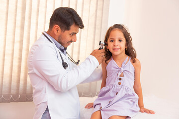 Doctor examines ear with otoscope in a pediatrician room. Medical equipment.