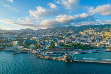 Fototapeta na wymiar Aerial drone view of Funchal city center panorama in Madeira island in the evening. It's Portugal's Autonomous Region and is located in Atlantic ocean