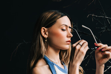 Fototapeta premium Young caucasian woman putting on eyeglasses.