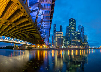 Fototapeta na wymiar Evening view at Moscow City reflecting at river Moscow from Dorogomilovsky bridge, panorama