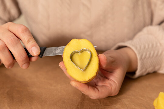 heart shaped potato stamp on craft paper. The process of decorating a gift for Valentine's Day. Getting ready for the celebration on February 14th.