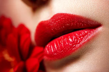 Fotobehang Sexy volle vrouwelijke lippen met rode lippenstift op de achtergrond van een bloem. Esthetische geneeskunde diensten lipvorm correctie, lipvergroting. © Aleksandr Rybalko