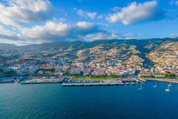 Fototapeta na wymiar Aerial drone view of Funchal city center and port panorama in Madeira island in the evening. It's Portugal's Autonomous Region and is located in Atlantic ocean