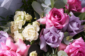 Close-up of a colorful bouquet of flowers. Large pink roses and eucalyptus leaves. On a light background, top view. Holiday concept. High quality photo
