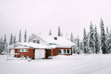 Brown wooden house in the snowy forest of finland. Winter landscape