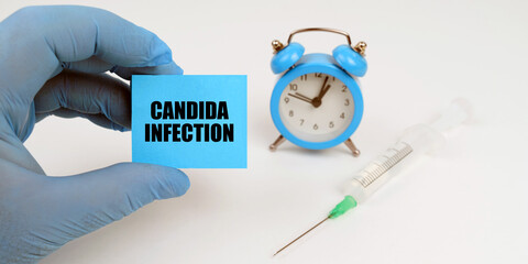 On the table is a syringe and an alarm clock, in his hand a notebook with the inscription - Candida...