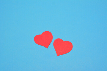 Fototapeta na wymiar two red paper hearts on blue background, place for text