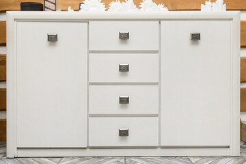 White wooden interior design detail with chest of drawers