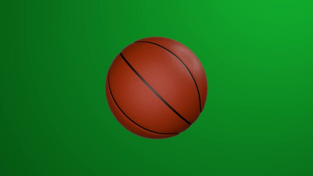 Classic basketball ball rotates on green background. Chroma key.