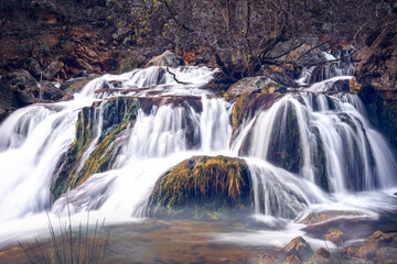 Fototapeta premium Guadalquivir river as it passes through the closed Utrero. Small waterfall on the Guadalquivir River in Cazorla.
