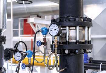 Flanged check valve with pressure gauge in a gas boiler room.